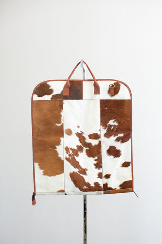 tan and white cowhide leather garment bag